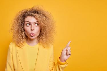 Überraschte, verwunderte Frau mit zusammengepressten Lippen schaut zur Seite